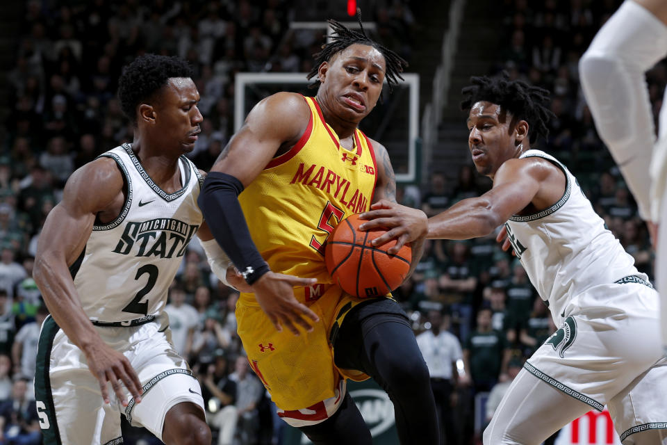 Maryland guard DeShawn Harris-Smith (5), center, drives against Michigan State guard Tyson Walker (2) and Michigan State guard A.J. Hoggard, right, during the first half of an NCAA college basketball game, Saturday, Feb. 3, 2024, in East Lansing, Mich. (AP Photo/Al Goldis)