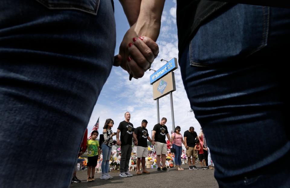 Adam Bowles, pastor of Castle Church in Norwich, Connecticut, at center left wearing an El Paso Strong T-shirt, along with his friend Matt Martinez, at center beside him, and brother-in-law Jono Wibberley decided to drive from their home to Dayton, Ohio, and then to El Paso to raise funds along the way for the victims of mass shootings in the cities. He said he decided on the drive after learning a man drove 10 hours from Allen, Texas, to El Paso to commit an act of hatred. He thought, “Love goes farther.” His drive took a day and 10 hours, he said. Once at the Walmart memorial site Saturday, Aug. 24, 2019, Bowles and his travel companions held a prayer circle with El Pasoans who were visiting the site.