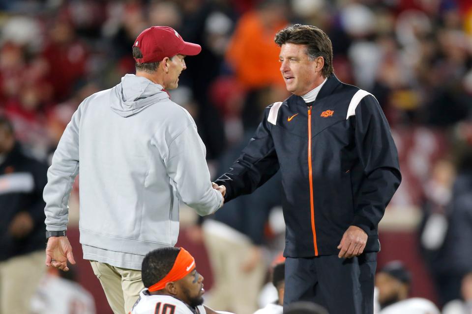 Oklahoma coach Brent Venables, left, and and Oklahoma State coach Mike Gundy shake hands before a Bedlam college football game between the University of Oklahoma Sooners (OU) and the Oklahoma State University Cowboys (OSU) at Gaylord Family-Oklahoma Memorial Stadium in Norman, Okla., Saturday, Nov. 19, 2022. 