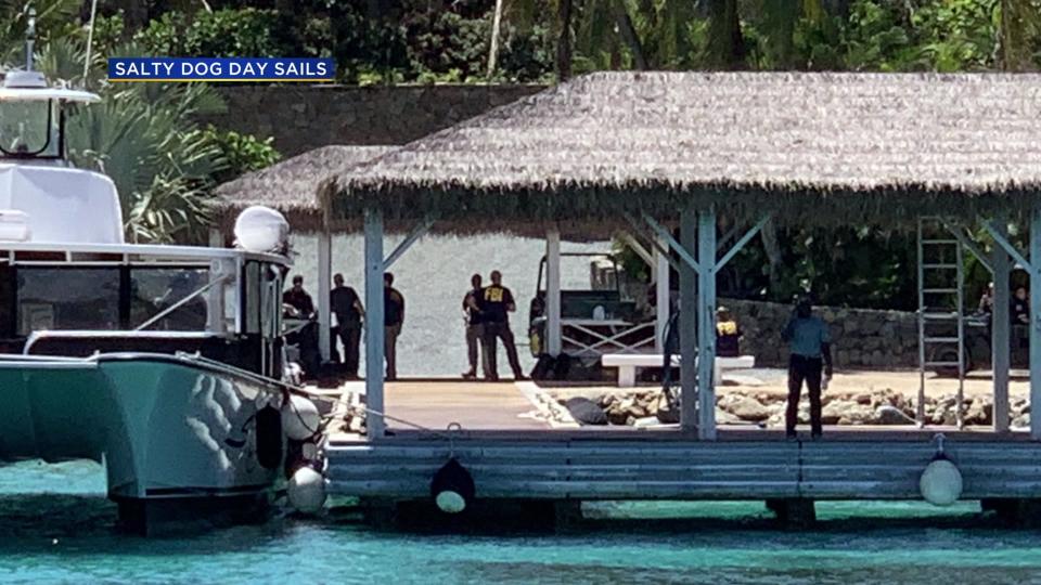 FBI agents and police arrive by boat to the private island owned by Jeffrey Epstein.  / Credit: Salty Dog Day Sails