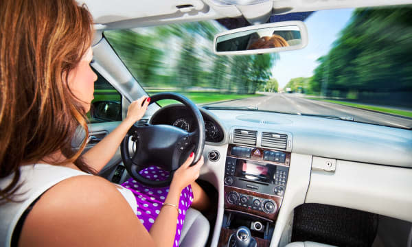 Young woman driving car. Fast motion effect.