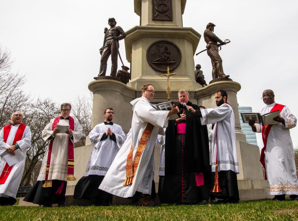 A Stations of the Cross procession stops in the Worcester Common on Good Friday.
