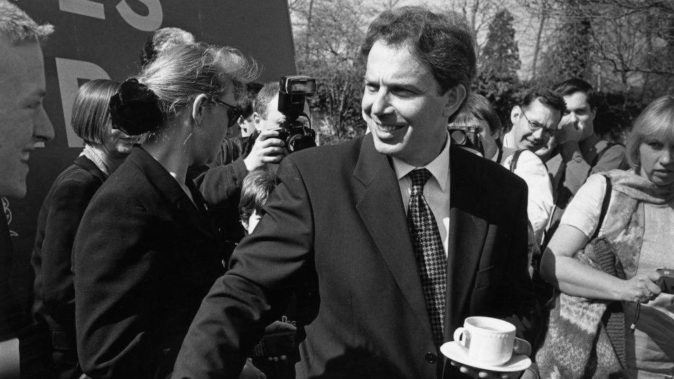 Tony Blair manages to balance tea and shake hands on the campaign trail in 1997. The Labour Party's election anthem was D:Ream club tune, "Things Can Only Get Better." - Steve Eason/Hulton Archive/Getty Images