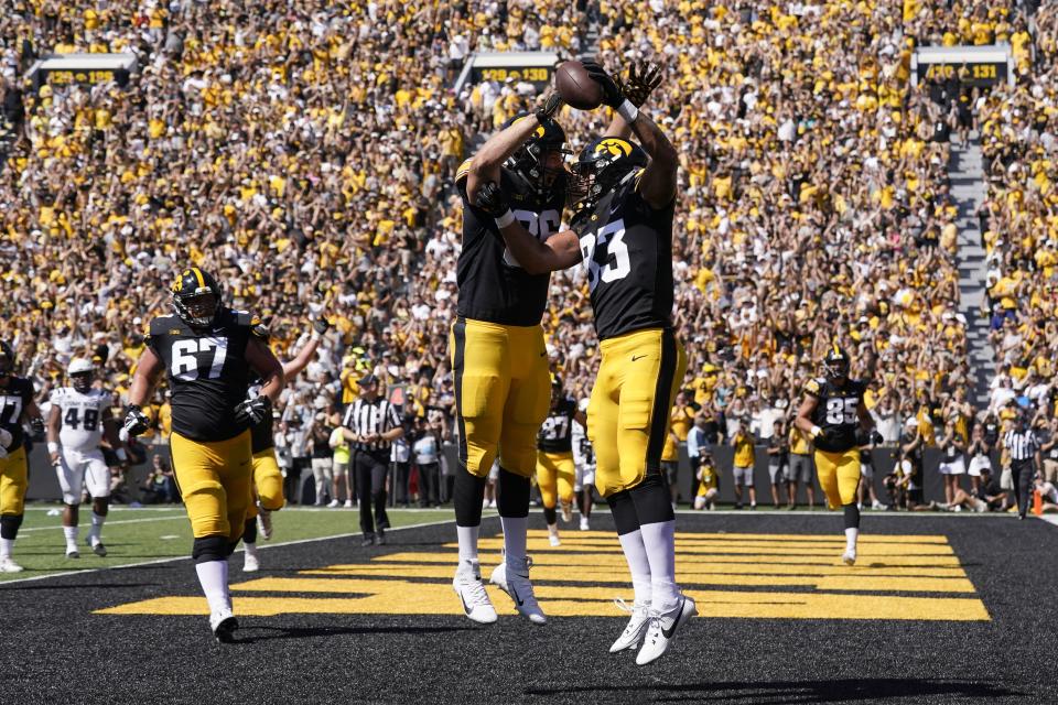 Iowa tight end Erick All (83) celebrates with teammate Steven Stilianos after catching a 3-yard touchdown pass during the first half of an NCAA college football game against Utah State, Saturday, Sept. 2, 2023, in Iowa City, Iowa. (AP Photo/Charlie Neibergall) | AP