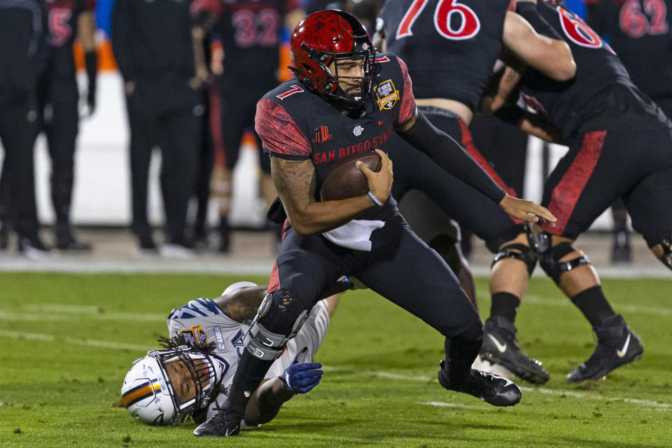 San Diego State quarterback Lucas Johnson (7) avoids a tackle during the first half of the Frisco Bowl NCAA college football game against UTSA, Tuesday, Dec. 21, 2021, in Frisco, Texas. (AP Photo/Sam Hodde)