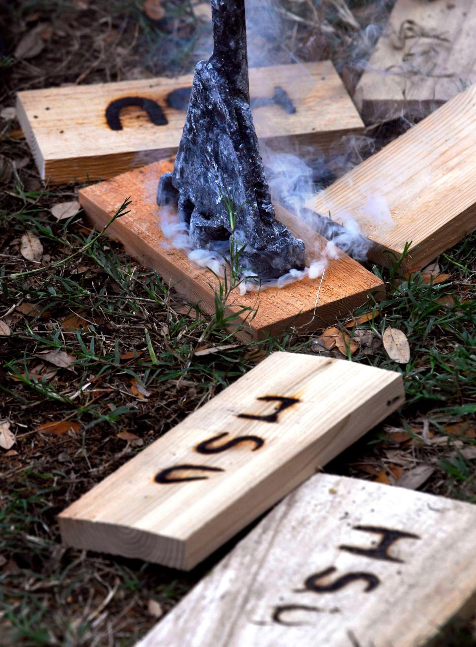 Nick Edwards uses a cattle brand to burn the Hardin-Simmons University initials into blocks of wood for Western Heritage Day at HSU April 25.