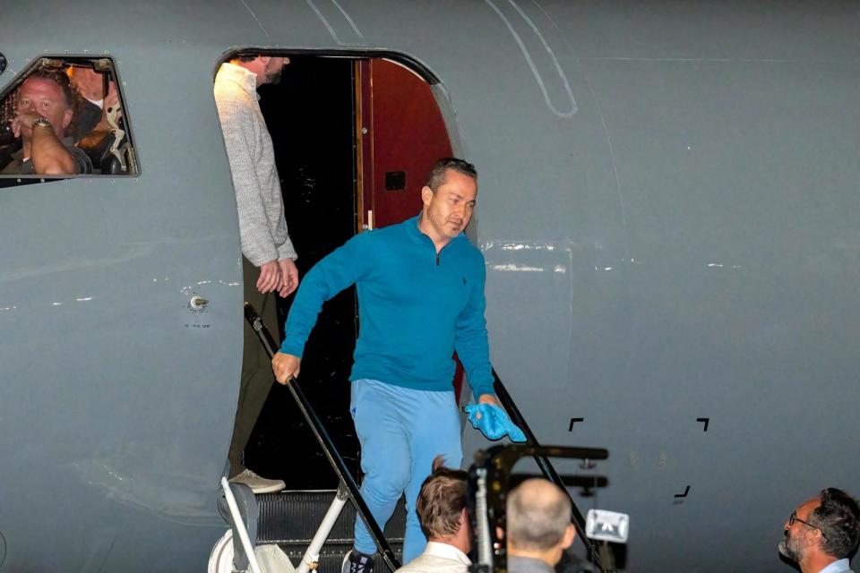 PHOTO: Eyvin Hernandez (C) steps off a plane upon arrival at Joint Base San Antonio Kelly Annex in San Antonio, Texas, on Dec. 20, 2023, after being freed amid a prisoner swap deal between the United States and Venezuela.  (Suzanne Cordeiro/AFP via Getty Images)