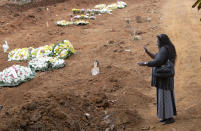 Vera Lucia Souza prays at the gravesite of her 47-year-old brother Paulo Roberto da Silva, who died of COVID-19, during his burial at the Sao Luiz cemetery in Sao Paulo, Brazil, Thursday, June 4, 2020. (AP Photo/Andre Penner)