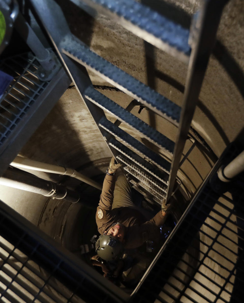 FILE - In this March 6, 2017, file photo, a member of the Border Patrol's Border Tunnel Entry Team ascends an entrance carved out by the Border Patrol leading to a tunnel spanning the border between San Diego and Tijuana, Mexico, in San Diego. Since 1990, U.S. officials have discovered at least 230 tunnels, most of them running from Mexico into California and Arizona. It's believed smugglers have spent hundreds of thousands of dollars to build the more sophisticated ones with ventilation and lighting. (AP Photo/Gregory Bull, File)