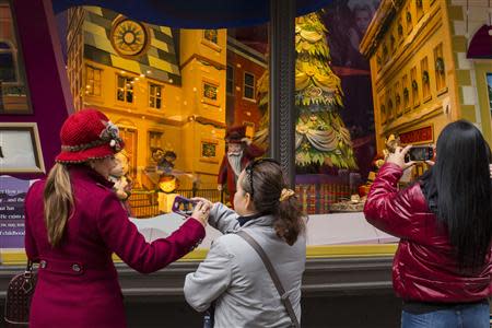 Pedestrians stop to look at holiday window displays at Macy's flagship store in New York, November 22, 2013. REUTERS/Lucas Jackson