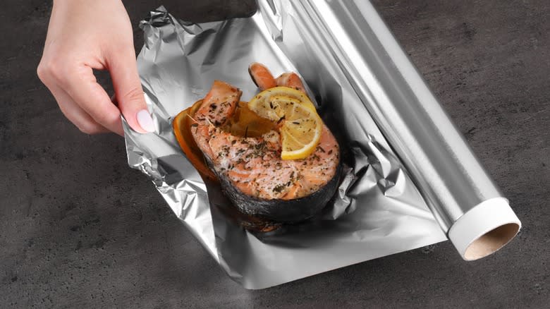 Fish with lemon on aluminum foil