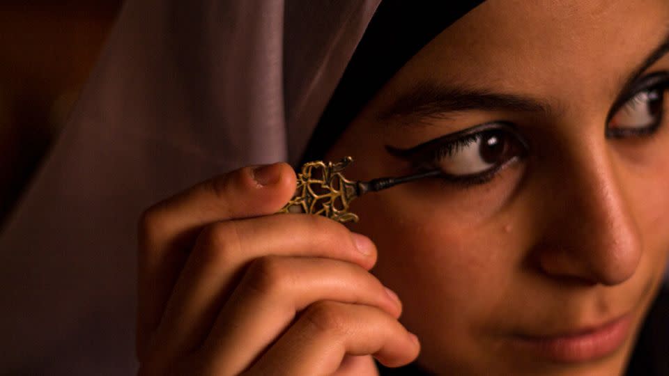 A bride paints on kohl at her wedding. Eyeliner has been used for medicinal, cultural and beautification purposes for thousands of years. - Fatima Shbair/Middle East Image/Redux