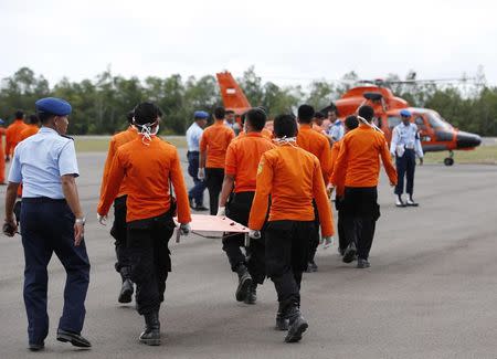 Indonesian Search and Rescue crews prepare to receive recovered bodies of AirAsia passengers recovered from the sea at the airport in Pangkalan Bun, central Kalimantan December 31, 2014. REUTERS/Darren Whiteside