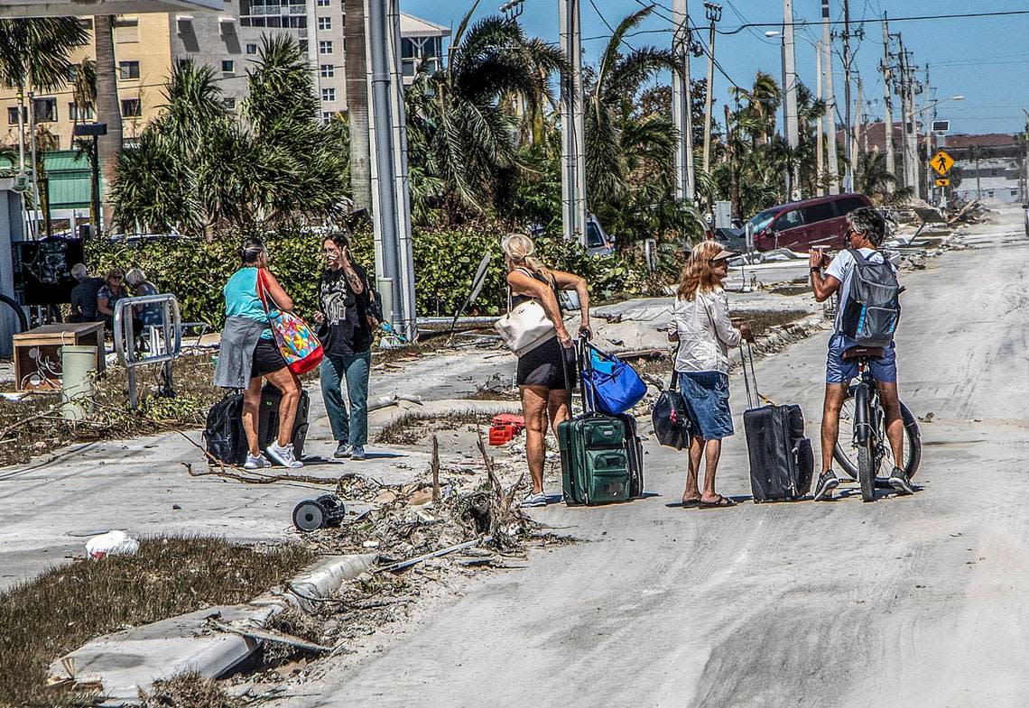 Residents walk along Estero Boulevard with suitcases as they leave the Fort Myers Beach Island, two days after Hurricane Ian hit Florida’s west coast as a Category 4 storm, on Friday September 30, 2022.