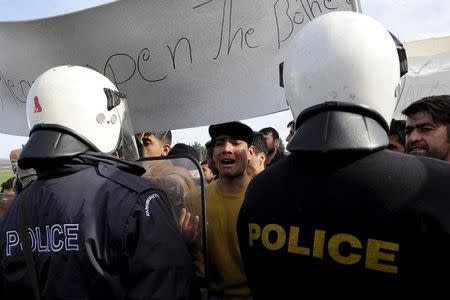 A migrant (C) reacts as refugees and migrants stage a protest next to a border fence at the Greek-Macedonian border, following a demand by Macedonia for additional identification from people seeking to cross the border and head to Western Europe, near the village of Idomeni, Greece, February 22, 2016. REUTERS/Alexandros Avramidis