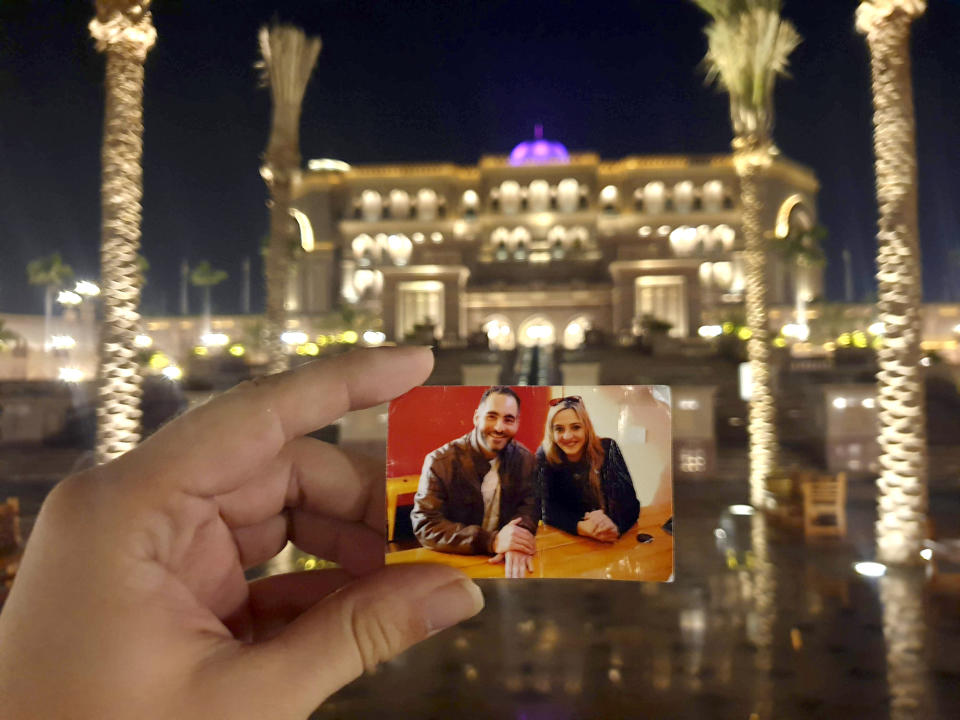 In this Aug.21, 2019 photo provided by Aya Al-Umari, a photo of Al Noor mosque shooting victim, Hussein Al-Umari, with his sister Aya Al-Umari, is held at the Emirates Palace by Aya in Abu Dhabi, United Arab Emirates. New Zealanders on Sunday, March 15, 2020, will commemorate those who died on the first anniversary of the mass killing, as the tragedy continues to ripple through the community. Three people whose lives were forever altered that day say it has prompted changes in their career aspirations, living situations and in the way that others perceive them. (Aya Al-Umari via AP)