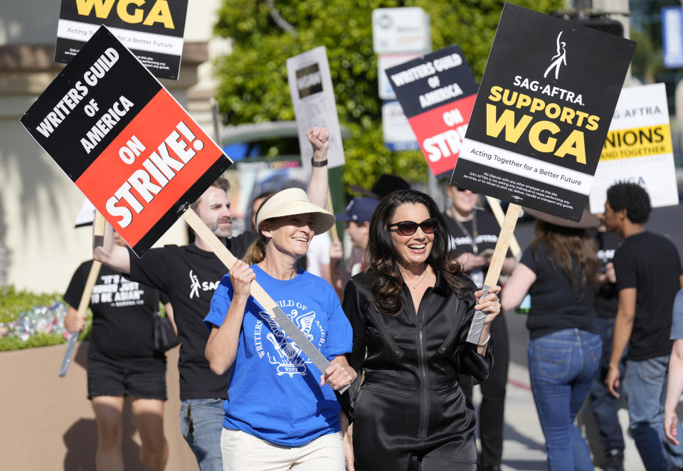 Meredith Stiehm, left, president of Writers Guild of America West, and Fran Drescher, president of SAG-AFTRA, take part in a rally by striking writers outside Paramount Pictures studio on May 8 in Los Angeles. 