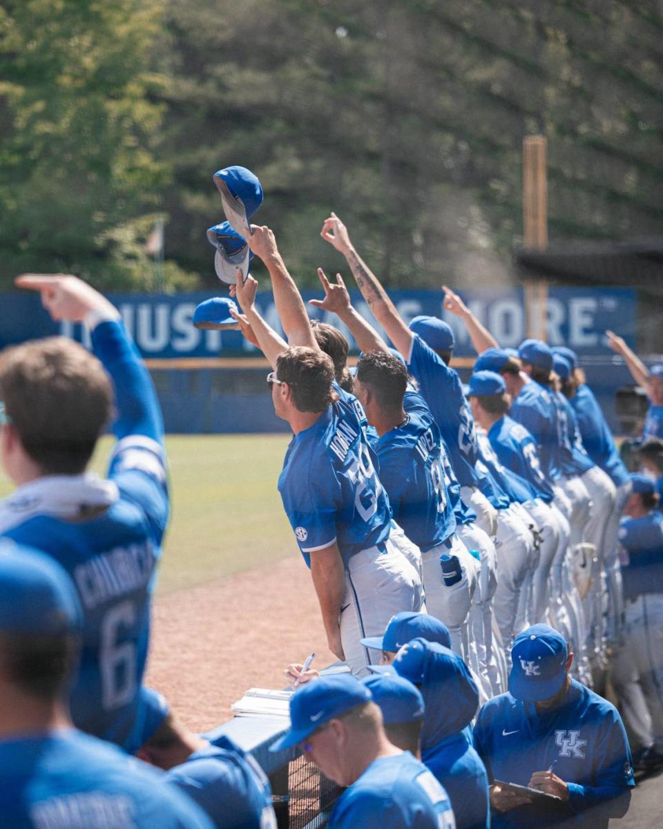 The Wildcats in the Kentucky dugout salute Nolan McCarthy’s leaping catch of a long fly ball in the second inning that robbed Arkansas’ Ben McLaughlin of a home run.