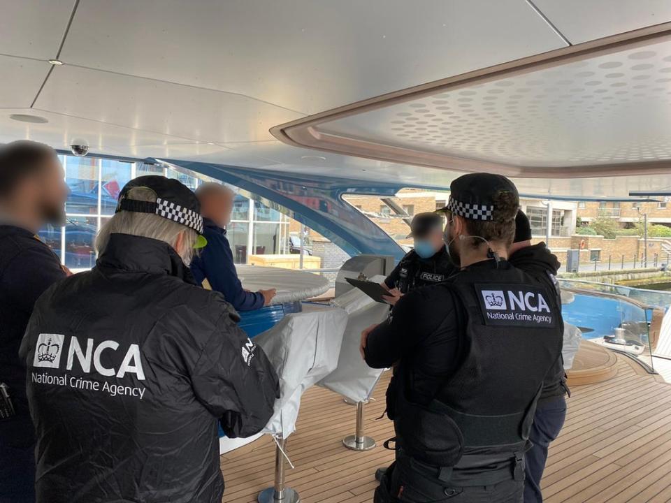 National Crime Agency (NCA) officers serve notice to the master on board the yacht (PA)