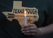 <p>A woman wearing a Texas t-shirt holds a lighted candle during a vigil held in the wake of a deadly school shooting at Santa Fe High School on Friday, May 18, 2018, in Galveston, Texas. (Photo: Stuart Villanueva/The Galveston County Daily News via AP) </p>