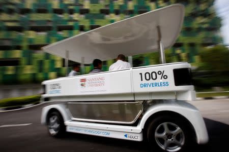 People ride on a driverless electric vehicle at the Nanyang Technological University (NTU) in Singapore September 4, 2013. REUTERS/Edgar Su