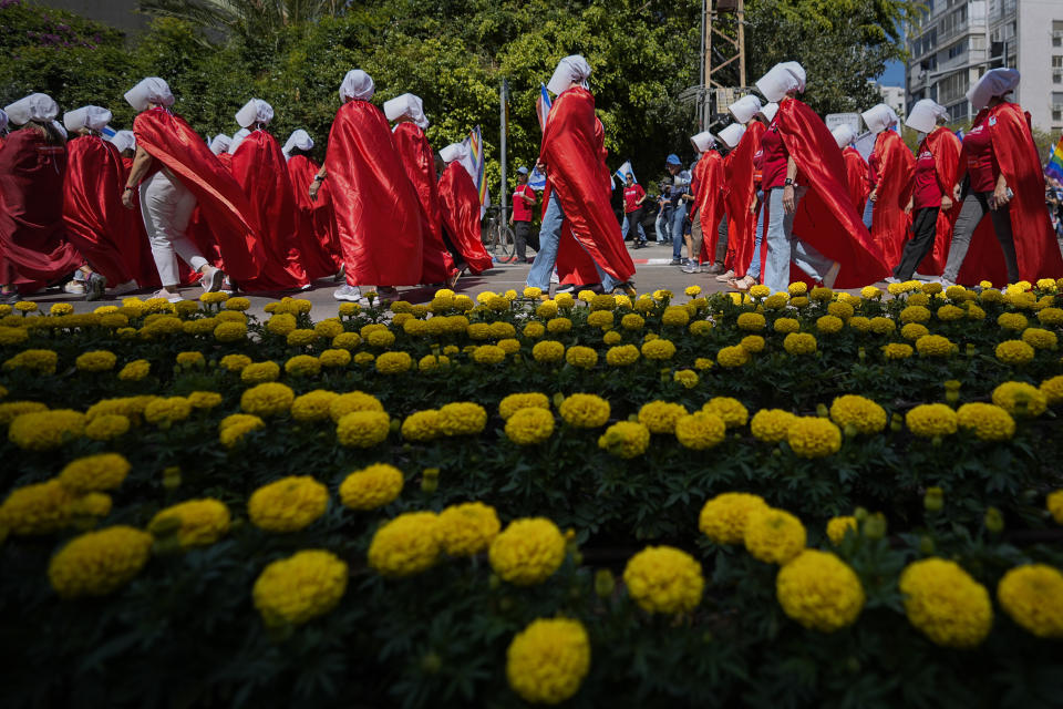 Israeli women's rights activists dressed as characters in the popular television series, "The Handmaid's Tale," protest plans by Prime Minister Benjamin Netanyahu's government to overhaul the judicial system, in Tel Aviv, Israel, Thursday, May 4, 2023. (AP Photo/Ohad Zwigenberg)