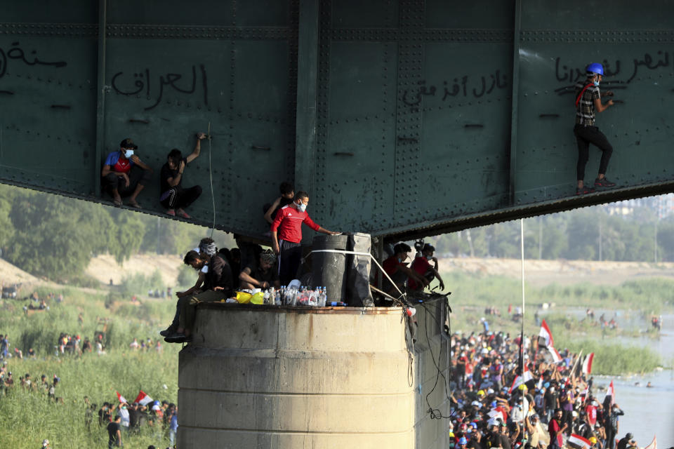 Anti-government protesters try to sneak to the Green Zone while Iraqi security forces close the the Joumhouriya bridge during a demonstration in Baghdad, Iraq, Friday, Nov. 1, 2019. (AP Photo/Hadi Mizban)