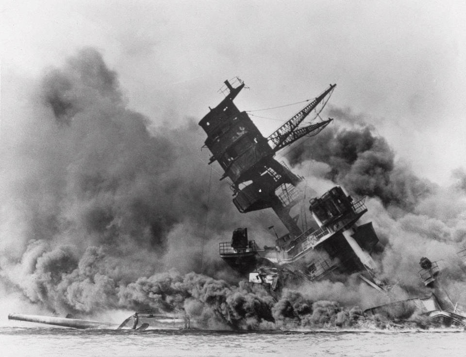 FILE - The battleship USS Arizona belches smoke as it topples over during a Japanese surprise attack on Pearl Harbor, Hawaii, on Dec. 7, 1941. A few centenarian survivors of the attack on Pearl Harbor are expected to gather at the scene of the Japanese bombing on Wednesday, Dec. 7, 2022, to remember those who perished 81 years ago. (AP Photo/File)