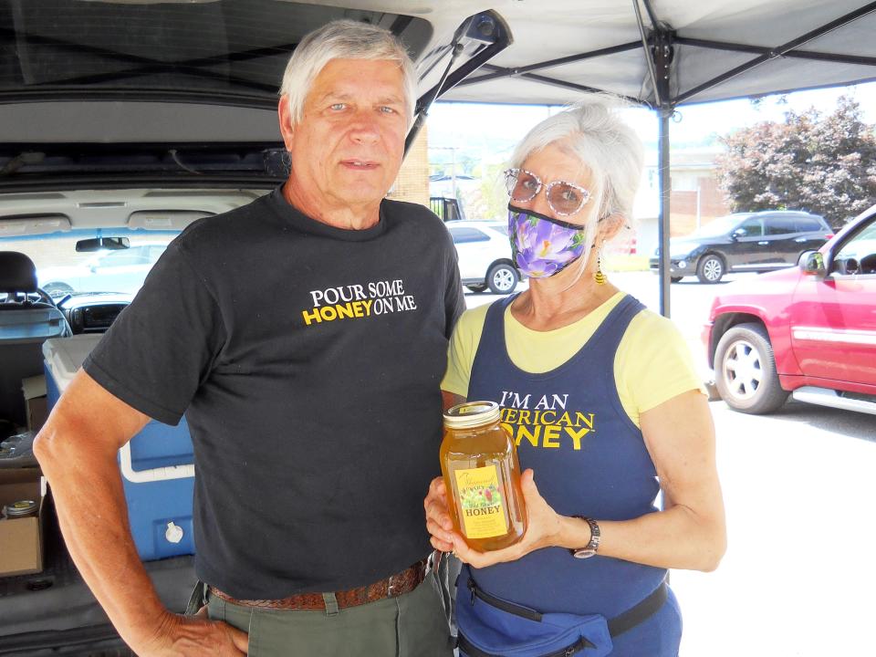 Don Sobczak and Naranza Blount show off honey they have for sale at the Oak Ridge Farmers' Market.