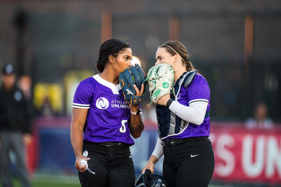 Pitcher Aleshia Ocasio chats with her catcher during an Athletes Unlimited game.