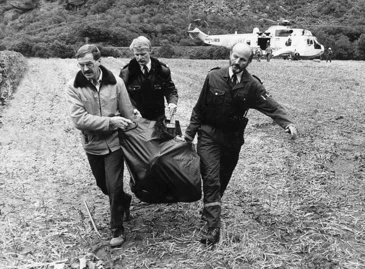 <span class="article__caption">The coroner and police with Carl's body; the Navy rescue 'copter in the background. </span> (Photo: John Long Collection)