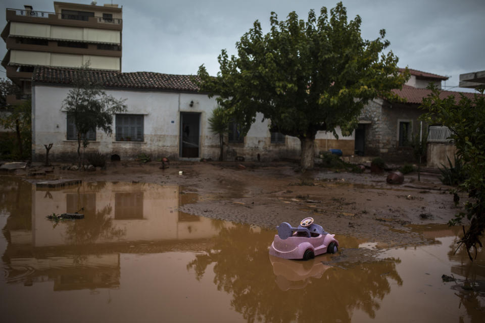A toy car is seen in a flooded street next to a damaged house in the town of Mandra. (Photo: Angelos Tzortzinis/AFP/Getty Images)
