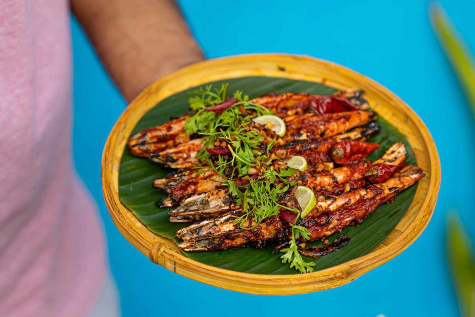 <p>Courtesy of Antonio@31</p> Grilled tiger prawns with balchão masala sauce, crispy garlic, and charred lime at the tapas bar Antonio@31, in Panaji, India.
