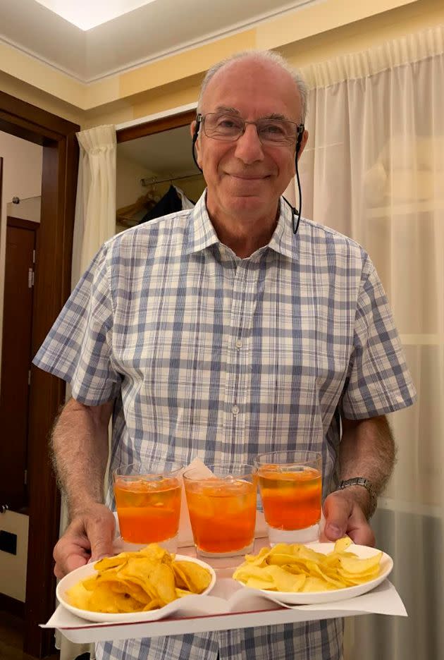 The author's dad in Milan, Italy, picking up spritzes at the hotel bar in 2019. 