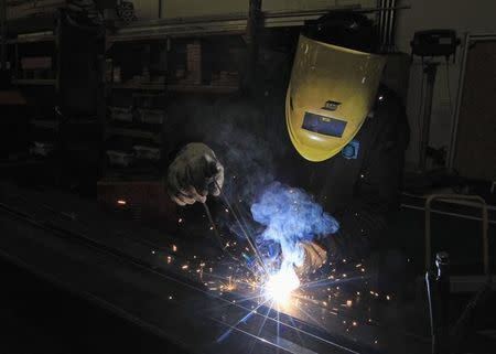 FILE PHOTO - A worker welds at a Portuguese exporting factory in Pontinha, on the outskirts of Lisbon March 18, 2013. REUTERS/Jose Manuel Ribeiro