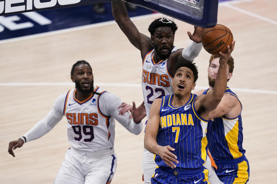 Indiana Pacers guard Malcolm Brogdon (7) shoots against Phoenix Suns' Jae Crowder (99) and Deandre Ayton (22) during the second half of an NBA basketball game, Saturday, Jan. 9, 2021, in Indianapolis. (AP Photo/Darron Cummings)