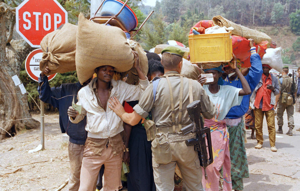 FILE - In this Aug. 15, 1994 file photo, a French soldier holds up a line of Rwandan refugees as they prepare to cross into Bukavu, in then Zaire on August 15, 1994. A report commissioned by the Rwandan government due to be made public on Monday, April 19, 2021 concludes that the French government bears "significant" responsibility for "enabling a foreseeable genocide" that left more than 800,000 dead in 1994 and that that France "did nothing to stop" the massacres. (AP Photo/Jean-Marc Bouju, File)