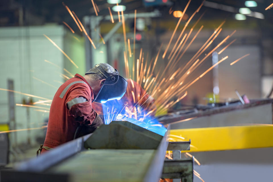 Welder using grinder in trailer factory