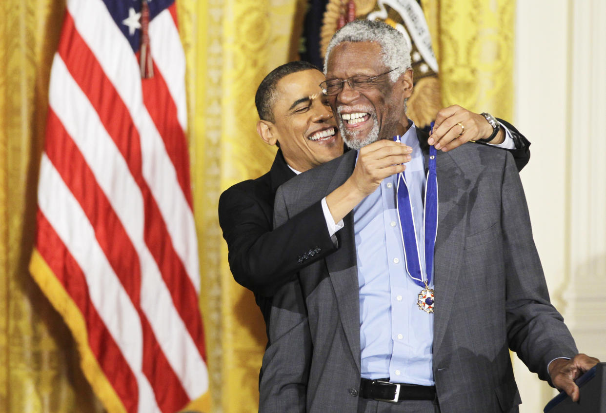 President Barack Obama reaches up to present a 2010 Presidential Medal of Freedom to basketball hall of fame member and former Boston Celtics coach and captain Bill Russell on Feb. 15, 2011, during a ceremony in the East Room of the White House. (Charles Dharapak / AP file)