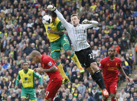 Norwich City's Bradley Johnson (3rd L) challenges Liverpool goalkeeper Simon Mignolet (2nd R) during their English Premier League soccer match at Carrow Road in Norwich April 20, 2014. REUTERS/Stefan Wermuth