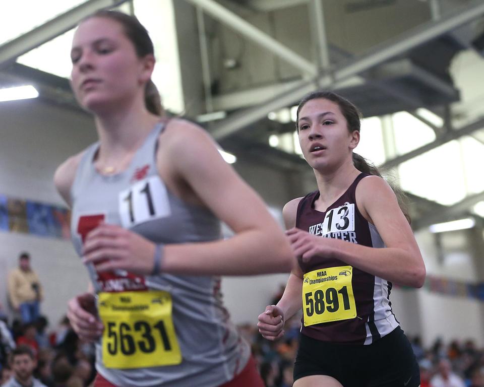 West Bridgewater’s Ella Dunbury, right, places first in the first heat of the 2 mile race at the MIAA Meet of Champions at the Reggie Lewis Track Center in Boston on Saturday, Feb. 25, 2023.