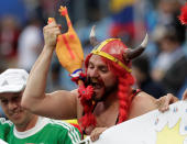 <p>A Belgian fan plays with a cockerel – France’s mascot </p>