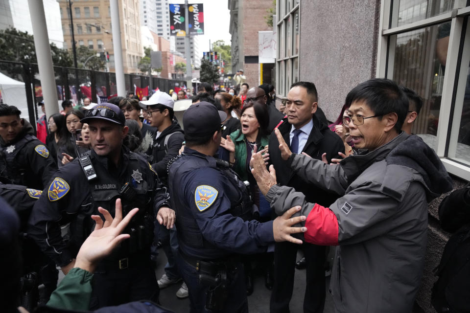 FILE - Supporters and critics of Chinese President Xi Jinping converge near the site of the APEC Summit, on Nov. 15, 2023, in San Francisco. A congressional commission will ask the Justice Department to investigate the role of the Chinese government after a group of anti-Beijing protesters claimed they were beaten and harassed by Beijing’s agents in November in San Francisco during an official visit by Chinese President Xi Jinping. The Chinese embassy has denied any involvement but said people had “voluntarily” travelled to San Francisco to welcome Xi. (AP Photo/Godofredo A. Vásquez, File)