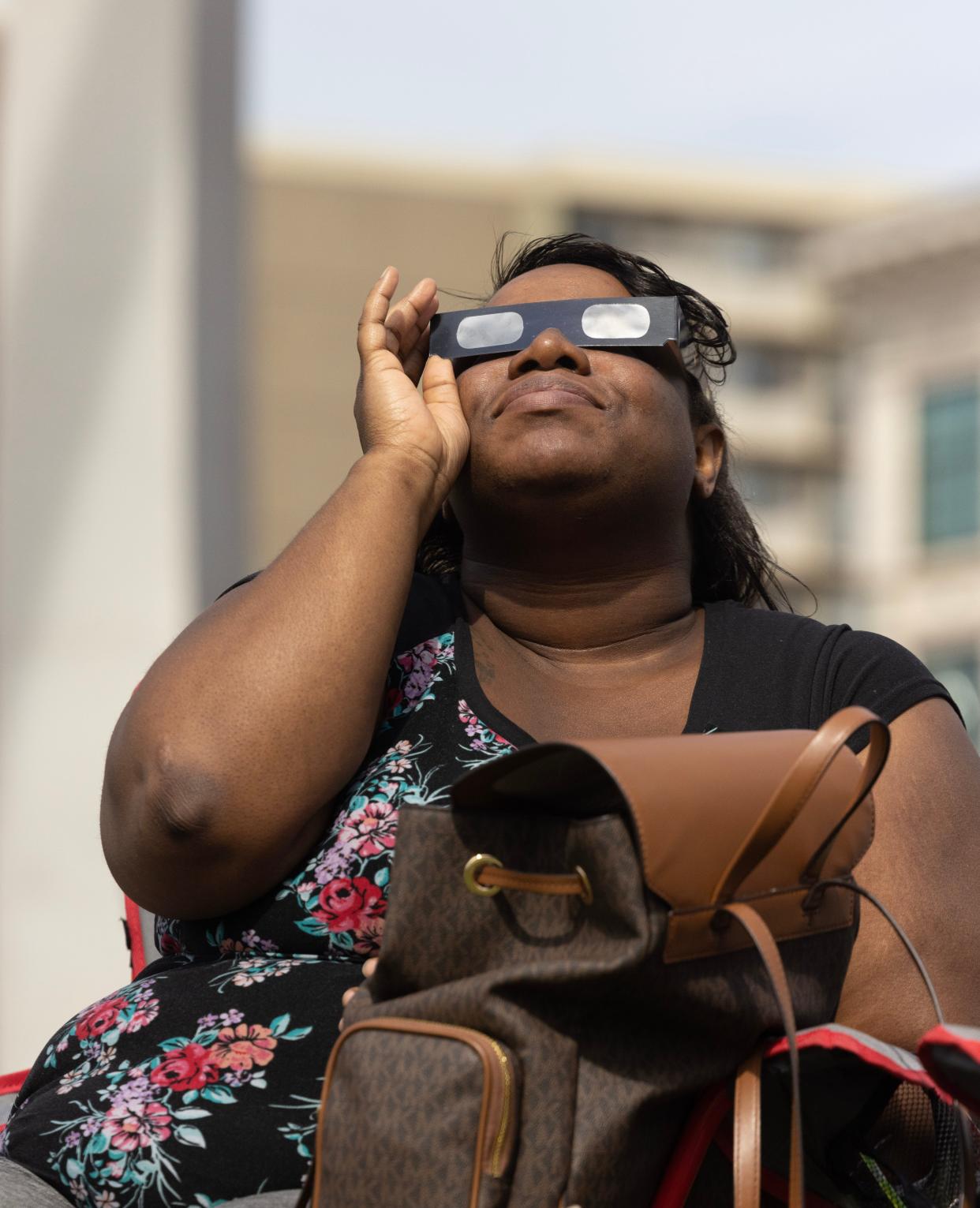 Melanie Belcher of Canton watches the eclipse in downtown Canton on Monday.