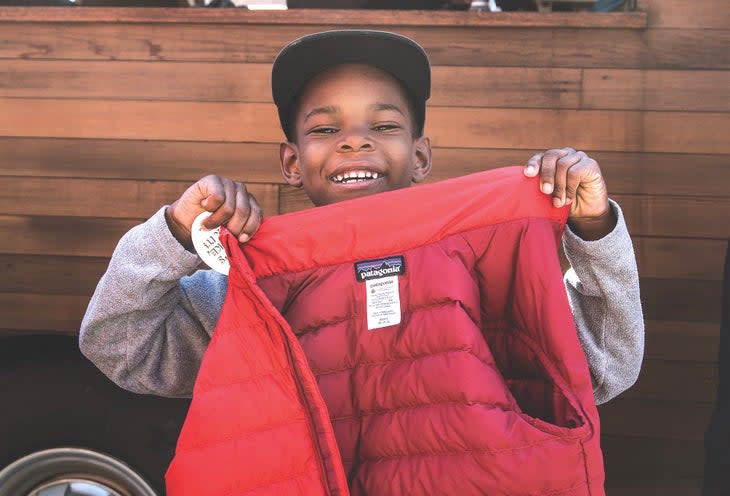 A boy shows off an upcycled Patagonia jacket saved from the landfill.