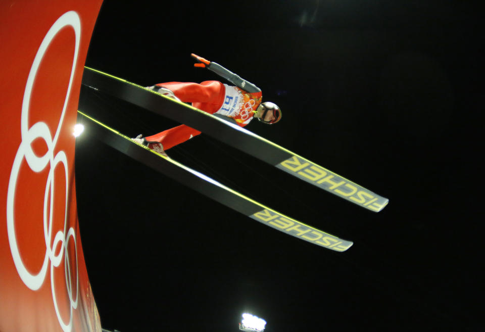 In this photo taken with a fisheye lens Poland's Kamil Stoch makes his trial jump during the ski jumping large hill qualification at the 2014 Winter Olympics, Friday, Feb. 14, 2014, in Krasnaya Polyana, Russia. (AP Photo/Dmitry Lovetsky)