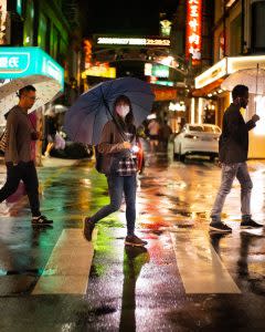 路人手持雨傘穿越斑馬線 | The photo shows the three walking through the pedestrians crossing in Taipei. (Courtesy of <a href="https://www.reddit.com/r/taiwan/comments/j16gvo/rainy_night_in_taipei/?utm_source=share&utm_medium=ios_app&utm_name=iossm" rel="nofollow noopener" target="_blank" data-ylk="slk:Nial Stewart;elm:context_link;itc:0;sec:content-canvas" class="link "><span>Nial Stewart</span></a>)