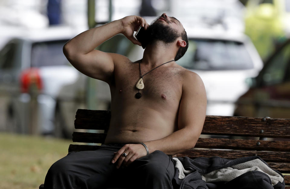 FILE - In this March 15, 2019, file photo, a man reacts as he speaks on a mobile phone outside a mosque in central Christchurch, New Zealand. More than 60 survivors and family members will confront the New Zealand mosque gunman during the four-day sentencing starting Monday, Aug. 24, 2020. Twenty-nine-year-old Australian Brenton Harrison Tarrant has pleaded guilty to 51 counts of murder, 40 counts of attempted murder and one count of terrorism in the worst atrocity in the nation's modern history. (AP Photo/Mark Baker, File)