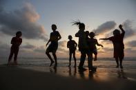 <p>Am Strand von Gaza spielen Kinder, während im Hintergrund die Sonne untergeht. (Bild: Ashraf Amra/APA/ZUMA/dpa) </p>