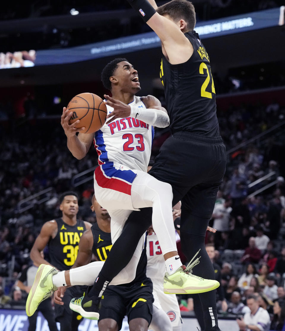 Detroit Pistons guard Jaden Ivey (23) drives to the basket as Utah Jazz center Walker Kessler (24) defends during the first half of an NBA basketball game, Thursday, Dec. 21, 2023, in Detroit. (AP Photo/Carlos Osorio)